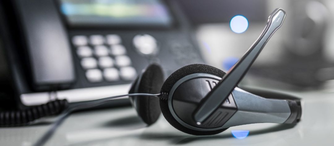 Telephone on a desk with the headset in front